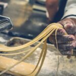 person sheeting dough